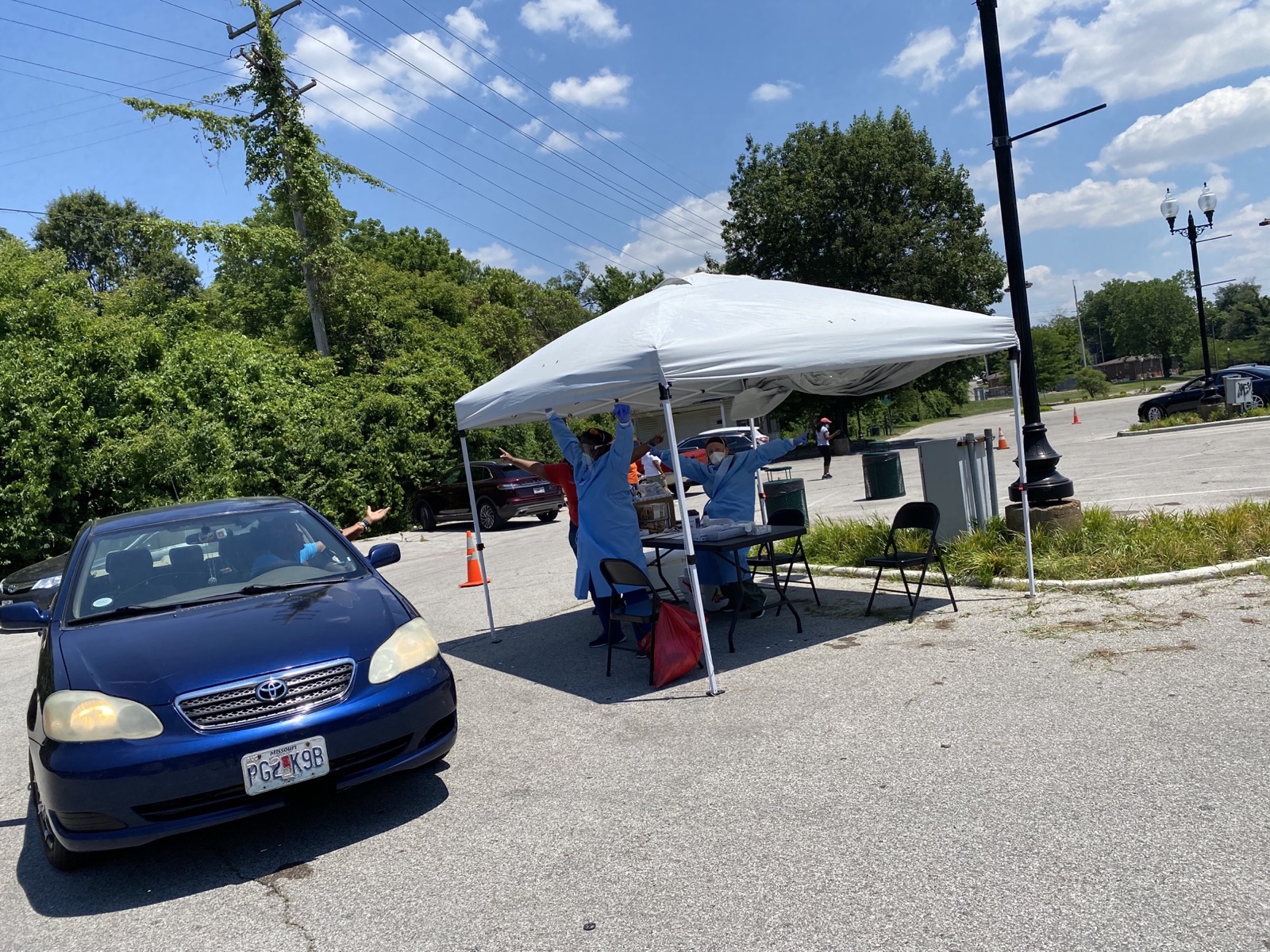 Volunteers providing resources to a visitor at a drive-through community distribution