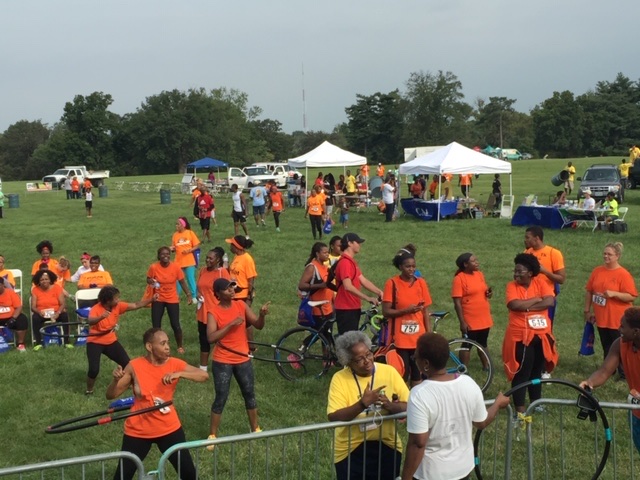 BKM run and walk participants in orange shirts gathered outdoors